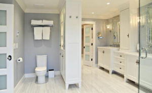 a bathroom with a toilet, sink, and mirror